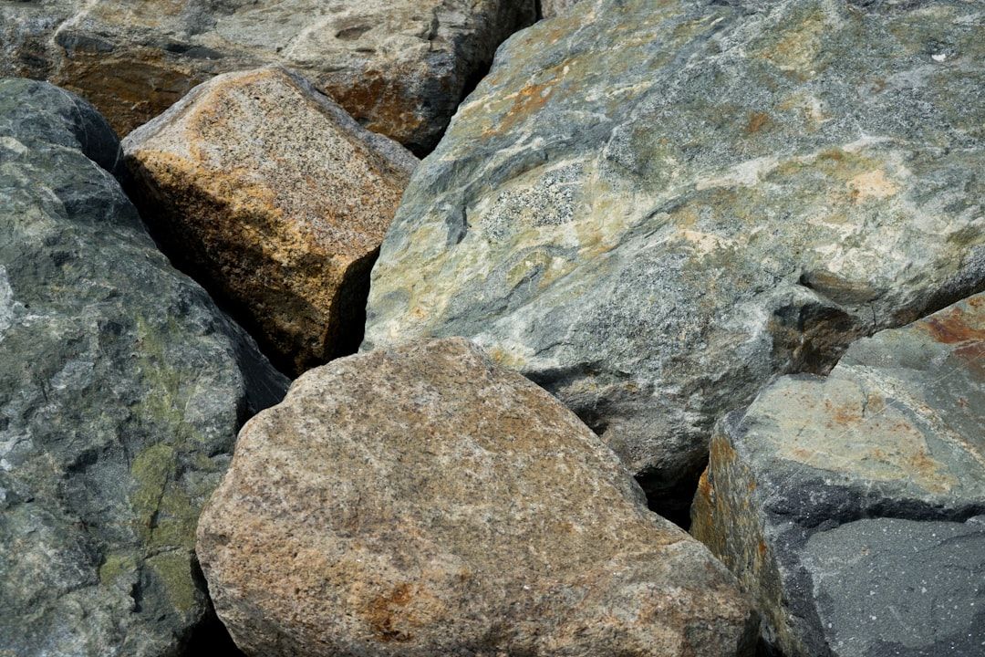 Närbild på en samling stora, grova stenblock i olika färger och texturer.